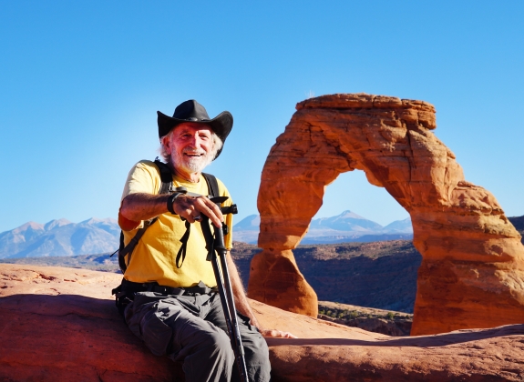 A senior hiker enjoying the views from the Delicate Arch area of Arches National Park